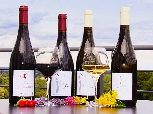 Bouteilles de Saumur-Champigny et de Saumur blanc du Domaine de Rocheville, avec un verre de rouge et un verre de blanc